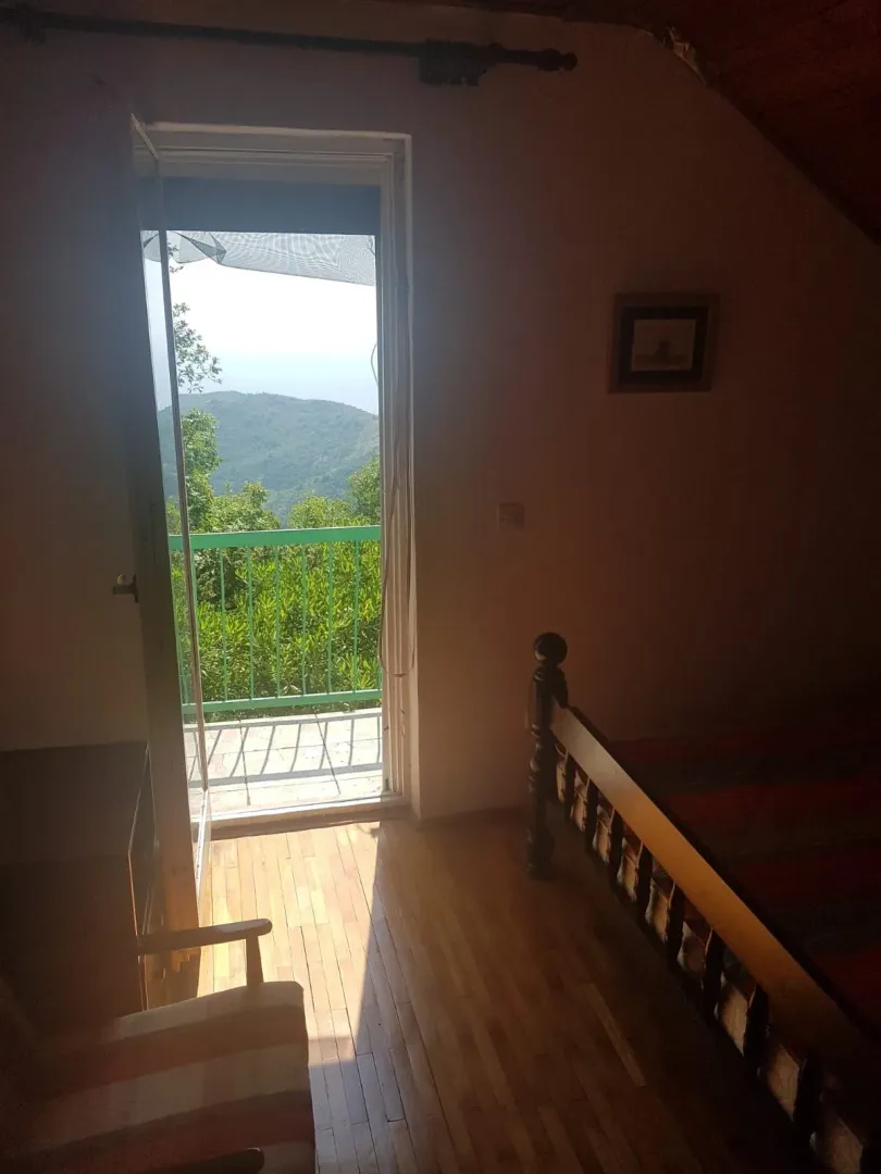 Bedroom with a bed and access to a terrace with a nature view.