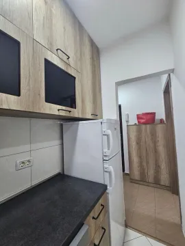 Manja kuhinja sa drvenim elementima i bijelim frižiderom. - image 9