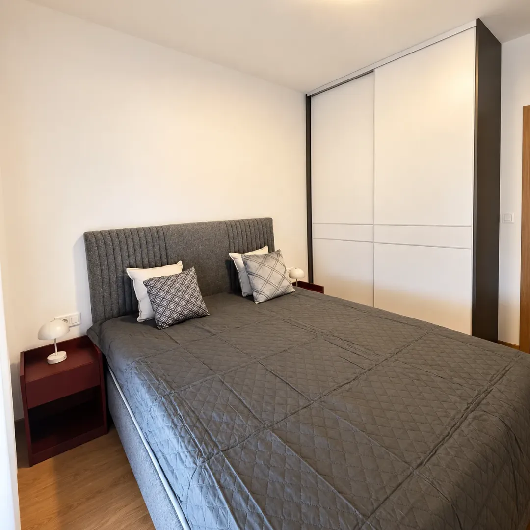 Bedroom with a double bed, nightstands, and a large built-in wardrobe.
