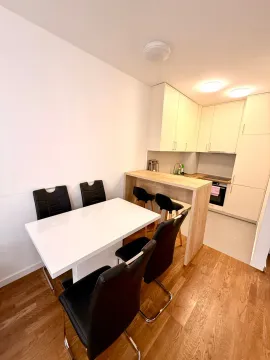 Bright kitchen featuring a dining table and a breakfast bar. - image 2