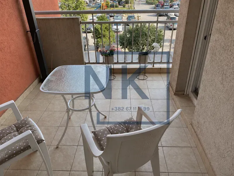Nenamešten balkon sa stolom i dve stolice.