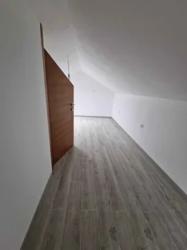 Prazna potkrovna prostorija sa drvenim podom i bijelim zidovima. - image 9