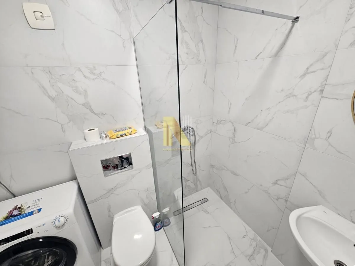 Moderno kupatilo sa tuš kabinom, wc šoljom i umivaonikom.