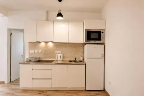 Compact white kitchen with built-in appliances and refrigerator. - image 2