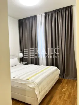 Furnished bedroom with a double bed and dark curtains. - image 7