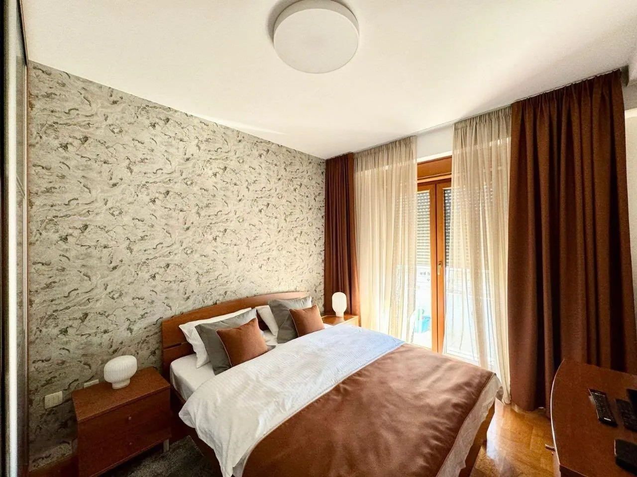 Furnished bedroom with a double bed and a window.