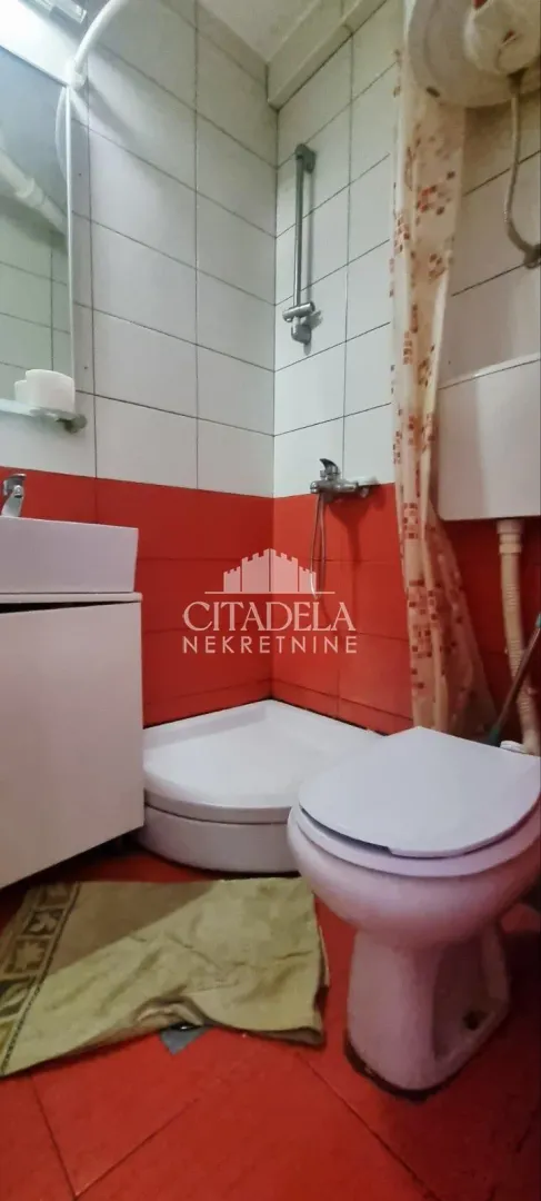 Manje kupatilo sa tuš kabinom, umivaonikom i toaletom.