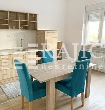 Small kitchen with a dining table and blue chairs.
