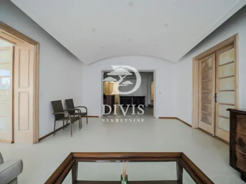Spacious living room with wooden doors and a glass coffee table. - image 5