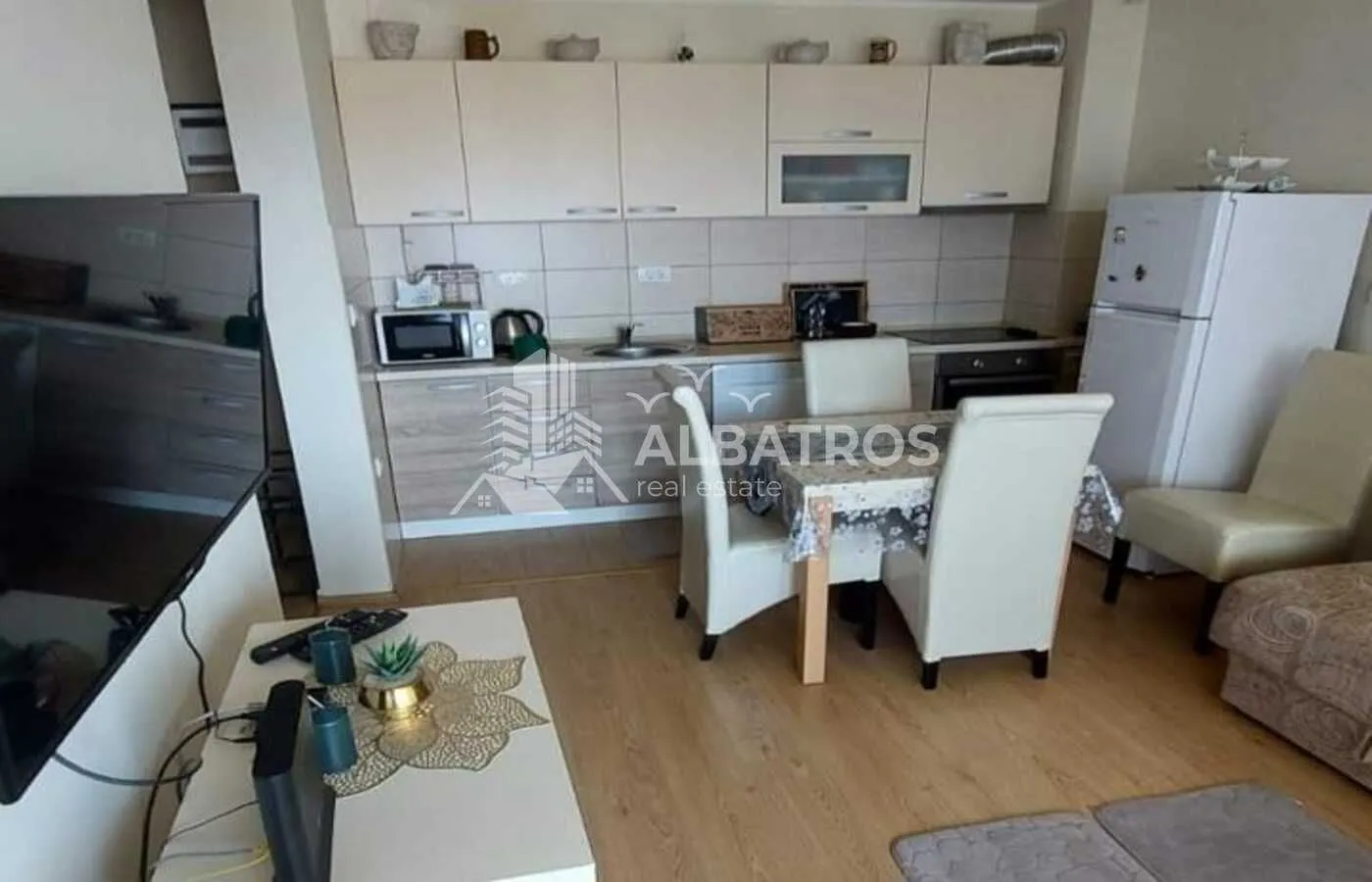 Small kitchen with a dining table and built-in units integrated into the living room area.