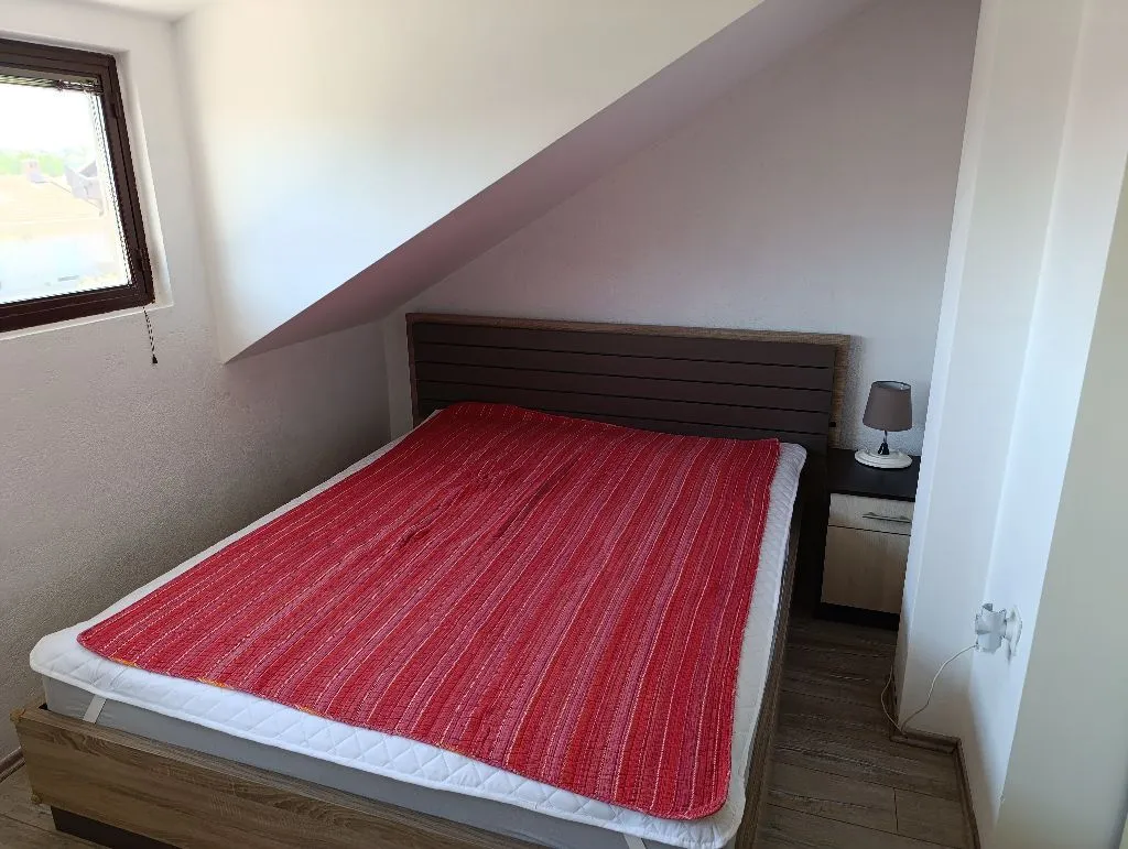 Attic bedroom with a double bed and a window.