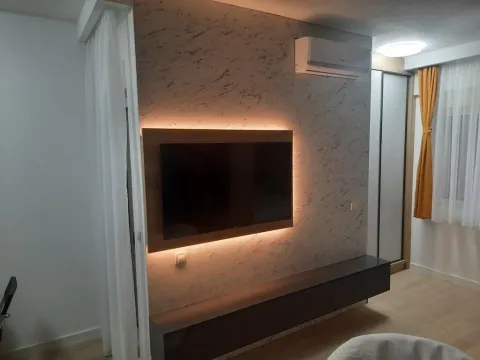 Living room with wall-mounted TV and ambient lighting. - image 11