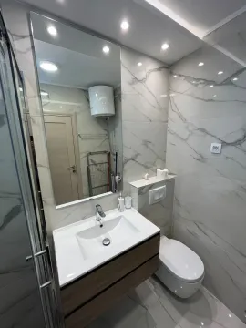 Modernly equipped bathroom with a washbasin and toilet. - image 8