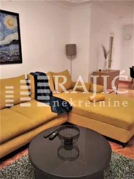 Living room with a yellow sofa and a round coffee table. - image 2