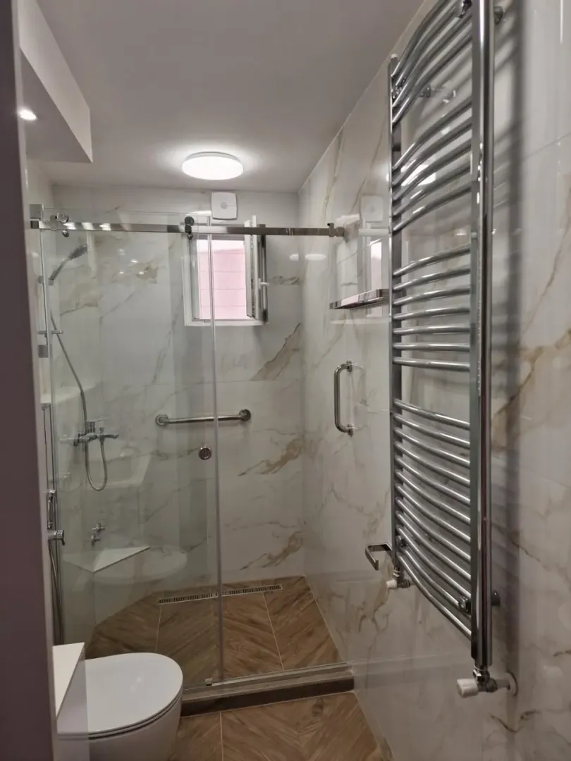 Moderno kupatilo sa tuš kabinom i ugradnom wc šoljom.
