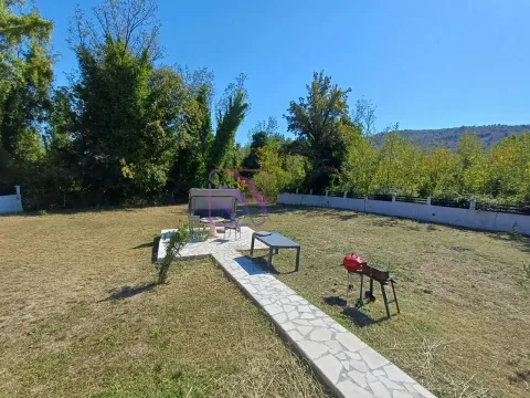 Spacious yard with a paved seating area and a barbecue. - image 20