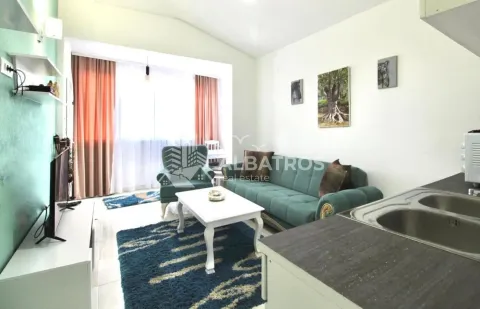 Living room with a sofa, coffee table and television, connected to the kitchen. - image 2
