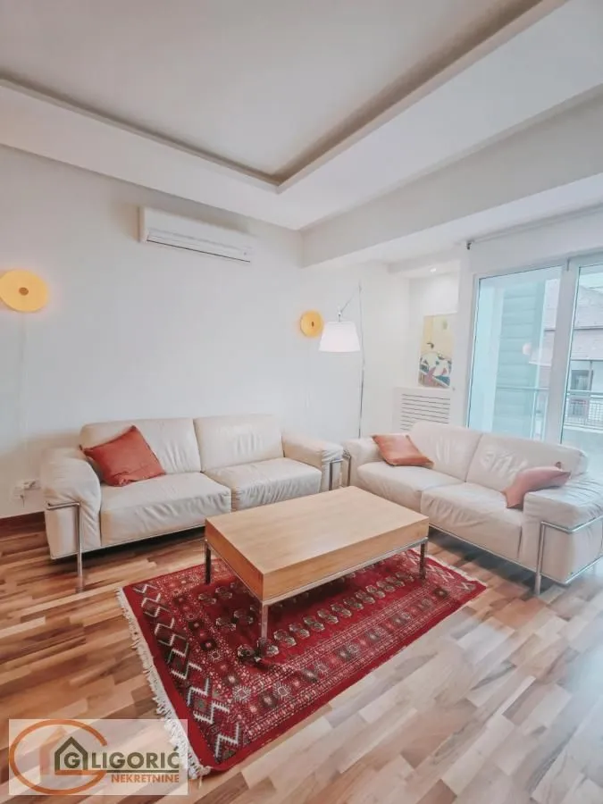 Living room with a sofa set, wooden coffee table, and a rug.