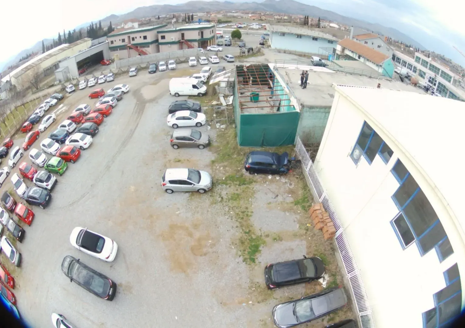 Aerial view of a parking lot and commercial buildings.