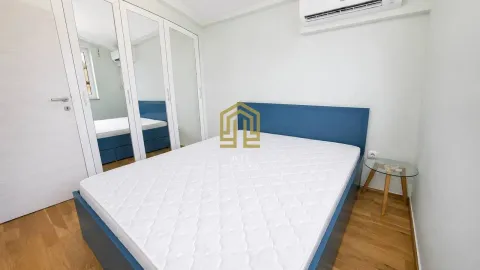 Bright bedroom with a blue bed and a built-in wardrobe with mirrors. - image 5