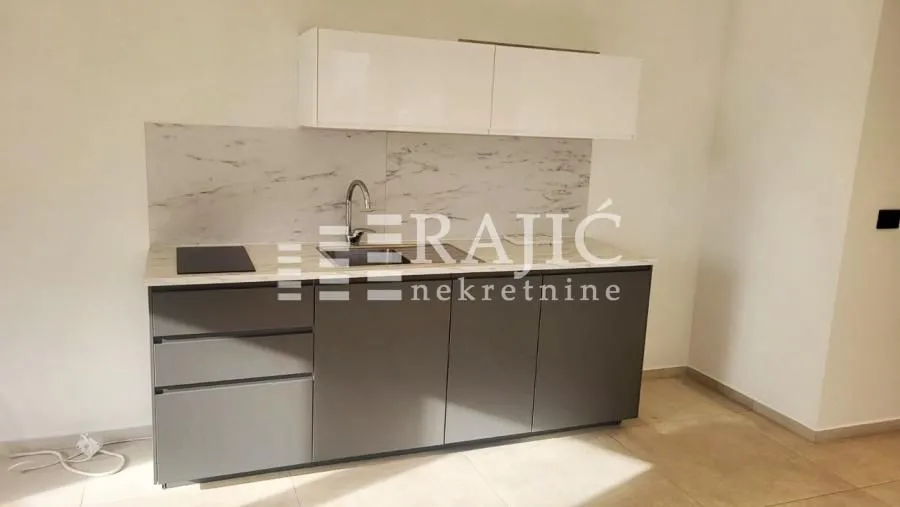 Small kitchen with dark lower cabinets and white upper cabinets.