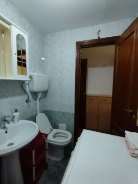 Simple bathroom with a sink and a view into the hallway. - image 5