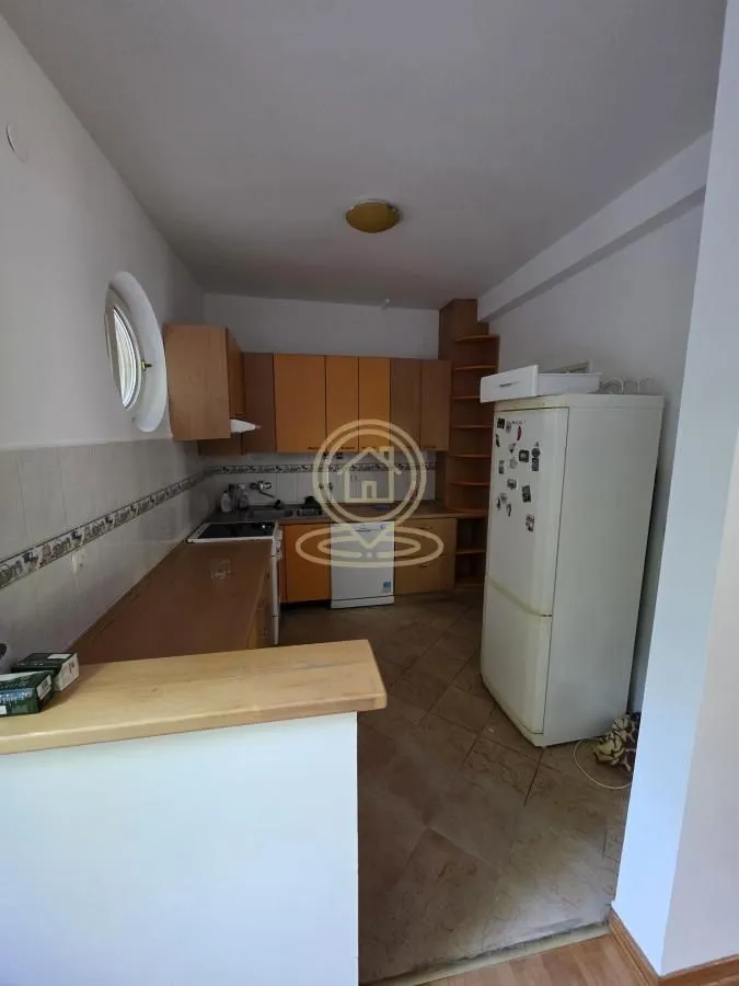 Kitchen with wooden cabinetry and white goods.