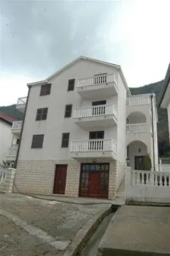 Pogled na spoljašnjost trospratne stambene zgrade sa terasama i kamenim detaljima u prizemlju. - image 5
