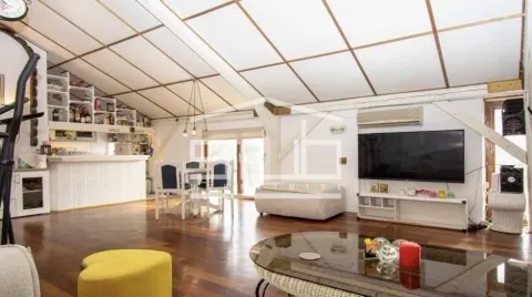 Spacious living room with a dining area and sloped ceiling in the attic. - image 11
