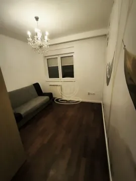 Dnevna soba sa kaučem, tamnim parketom i dekorativnim lusterom. - image 3