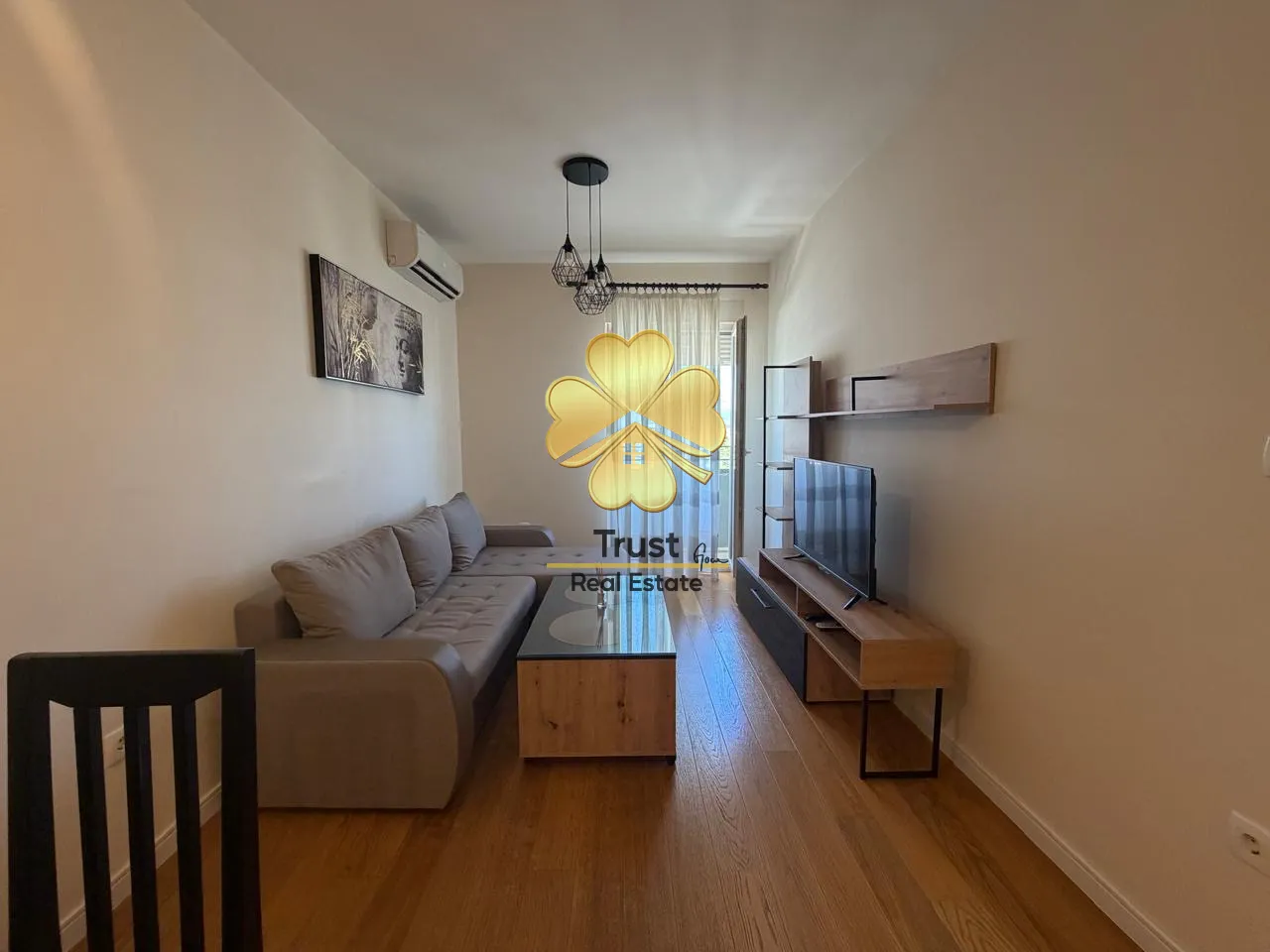 Living room with sofa, TV unit and dining table.
