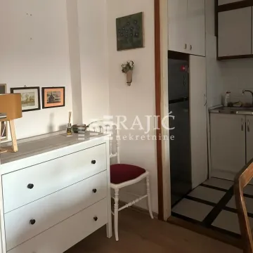 Living room with a chest of drawers and a view of the kitchen. - image 3