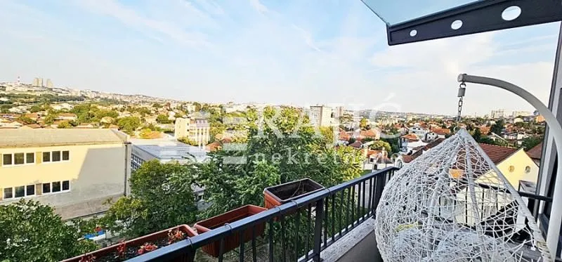 Balcony with seating furniture and city view.