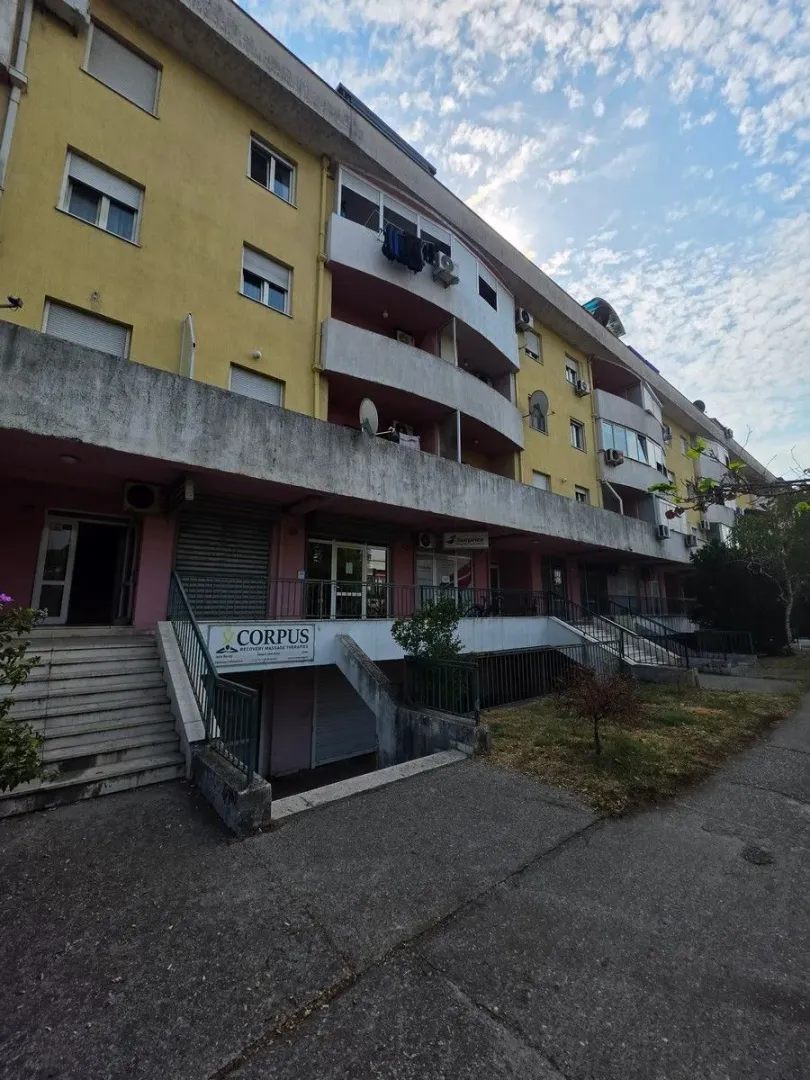 View of the exterior of a residential building with commercial space on the ground floor.