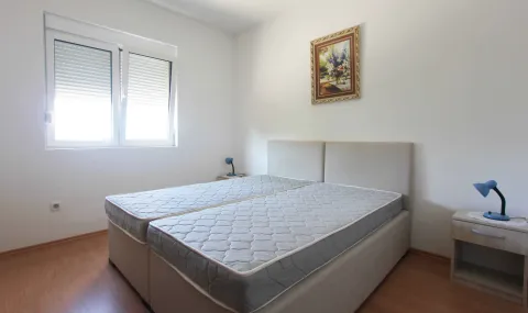 Jednostavno namještena spavaća soba sa dva spojena kreveta i noćnim stolovima. - image 3