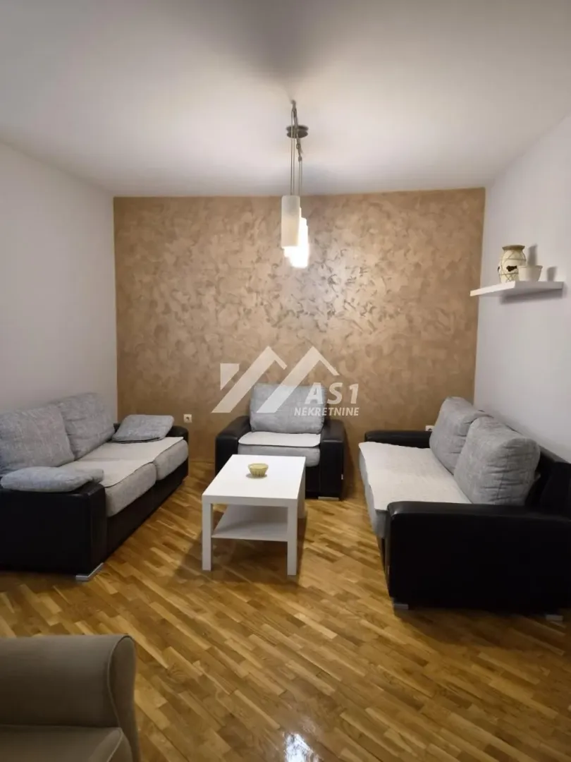 Dnevna soba sa garniturom za sedenje i stočićem.