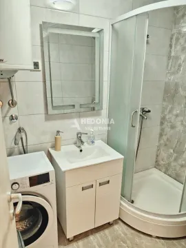 Kupatilo opremljeno umivaonikom, tuš kabinom i veš mašinom. - image 6
