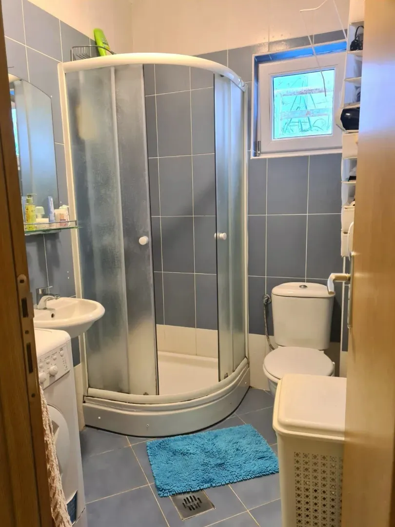 Manje kupatilo sa tuš kabinom, umivaonikom i wc šoljom.