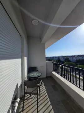 Furnished balcony with seating set and city view. - image 10