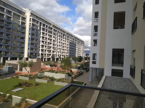 Pogled sa terase na uređeno dvorište i moderne stambene zgrade. - image 2