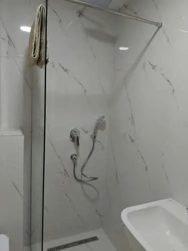 Modern bathroom with a walk-in shower and marble tiles.