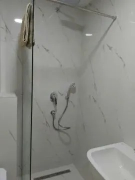 Modern bathroom with a walk-in shower and marble tiles. - image 5
