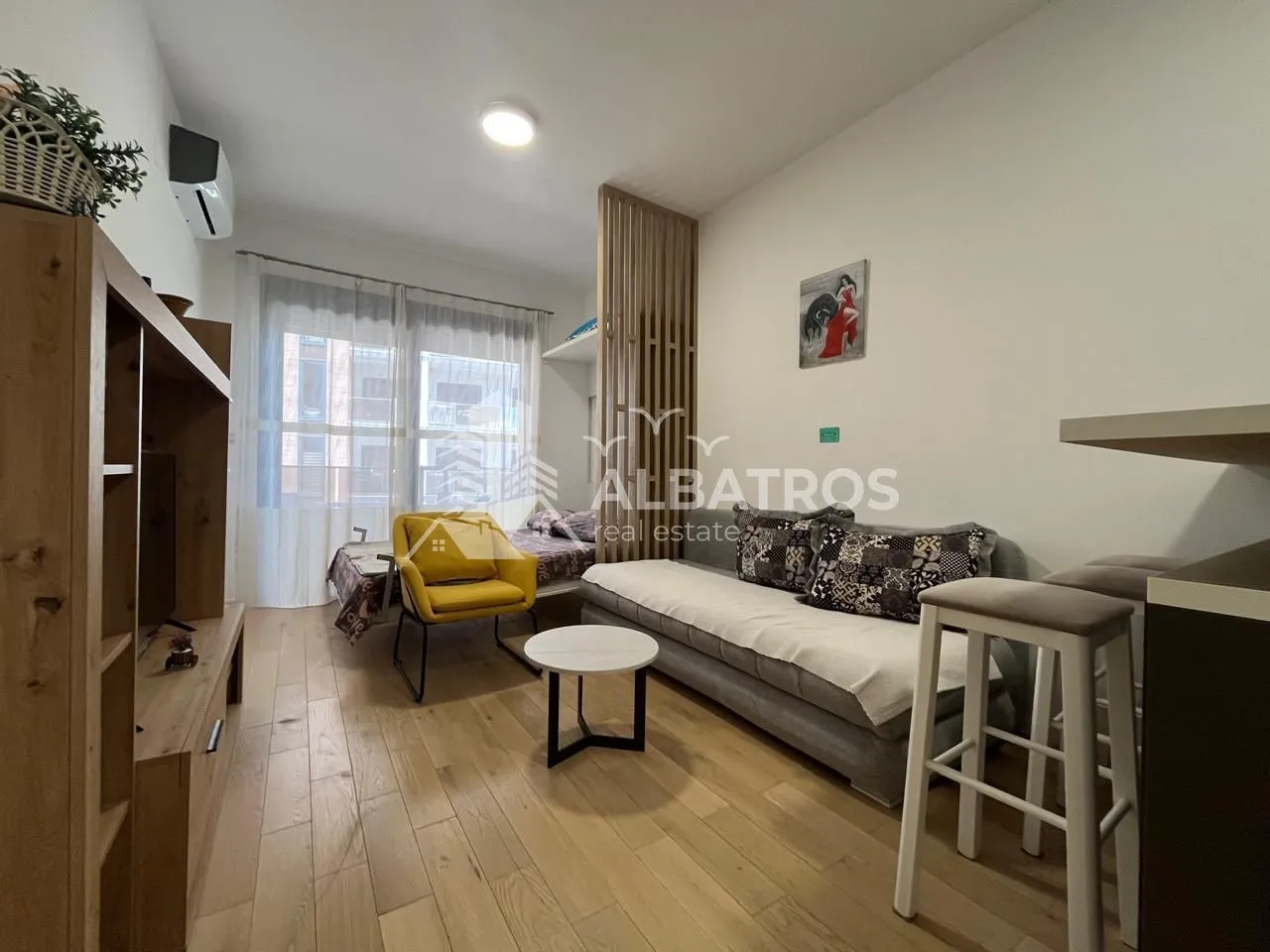 Small living room with a sofa, armchair and TV unit.