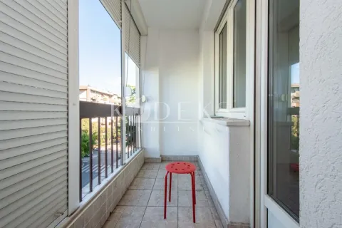 Small enclosed balcony with ceramic tiles and a red stool. - image 13