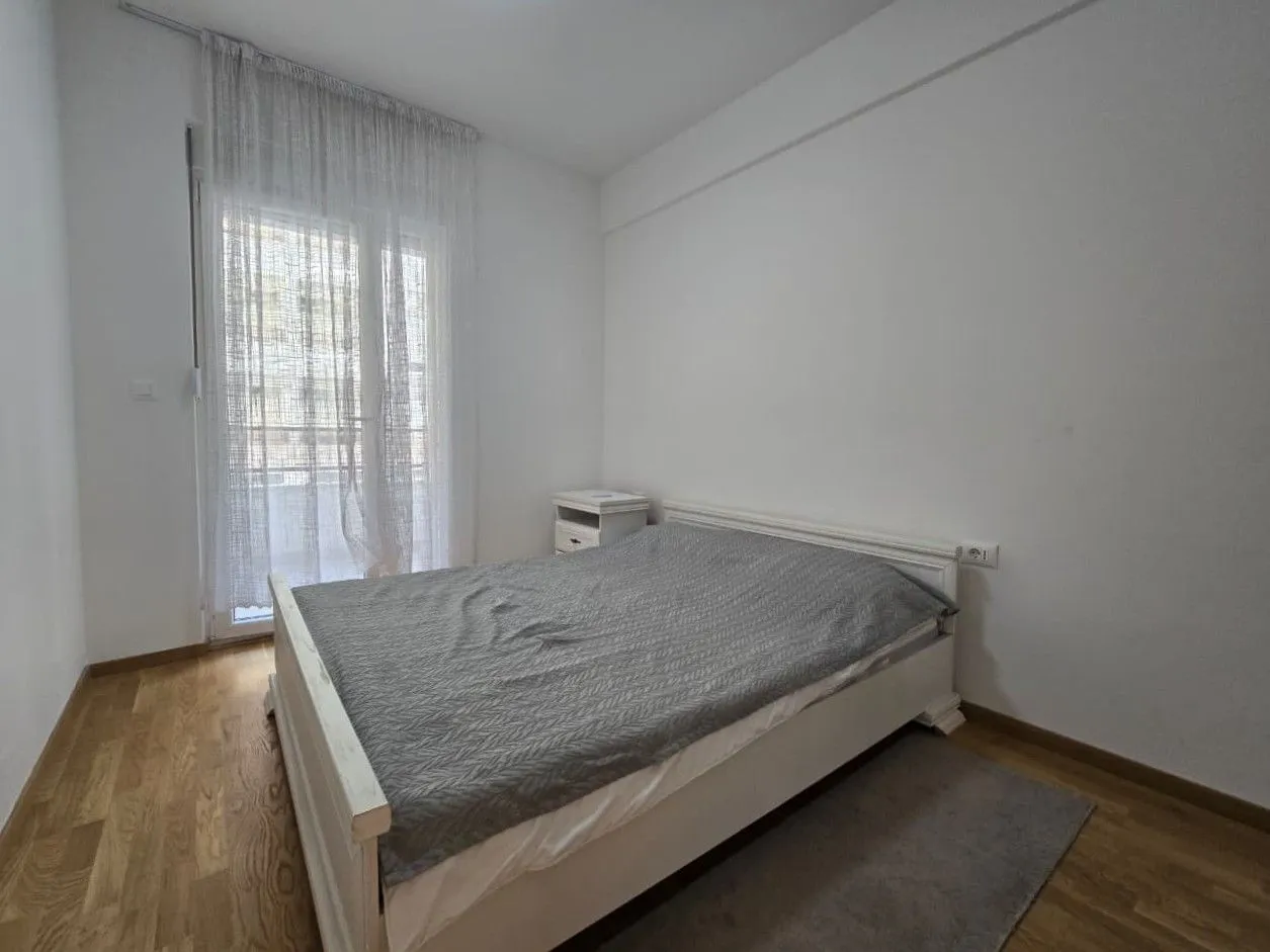 Svjetla spavaća soba sa bračnim krevetom i izlazom na terasu.