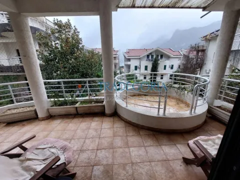 Velika natkrivena terasa sa keramičkim pločicama i pogledom na okolne zgrade i brda. - image 19
