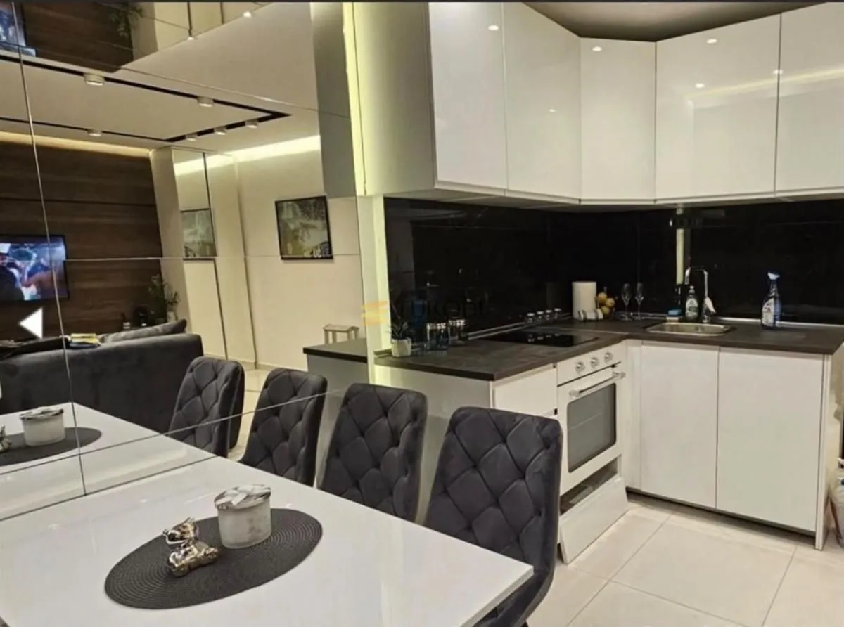 Modern kitchen with dining area and built-in appliances.