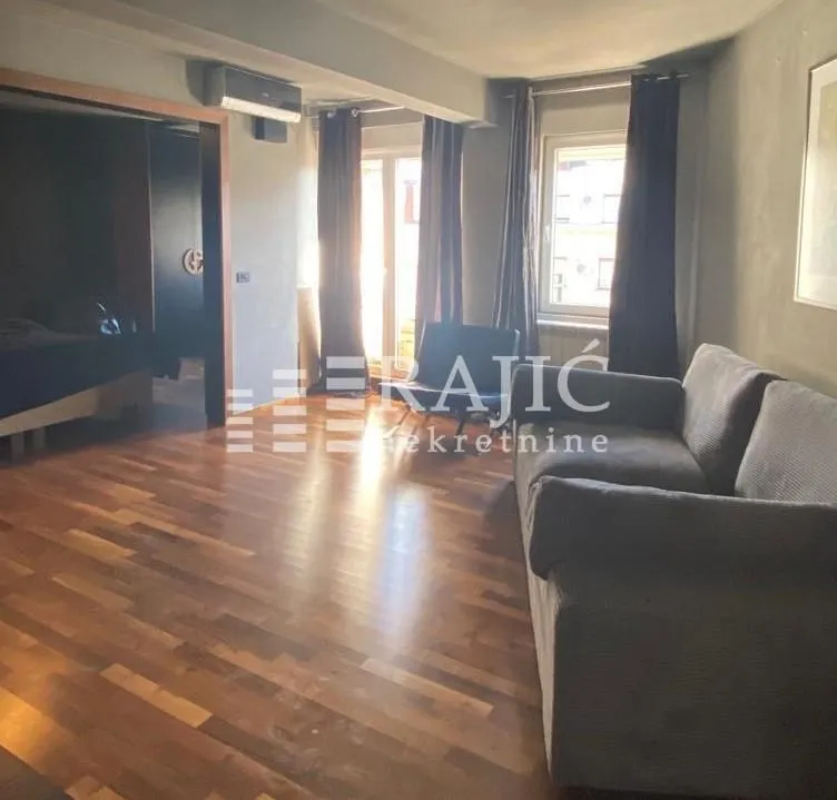 Living room with a sofa and wooden floor.