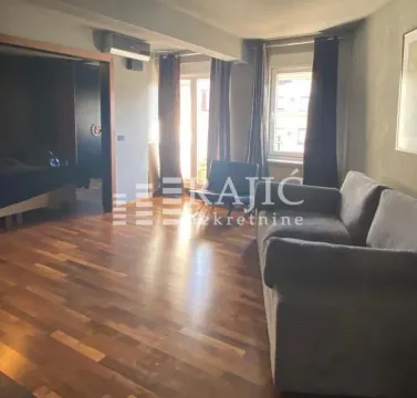 Living room with a sofa and wooden floor. - image 2