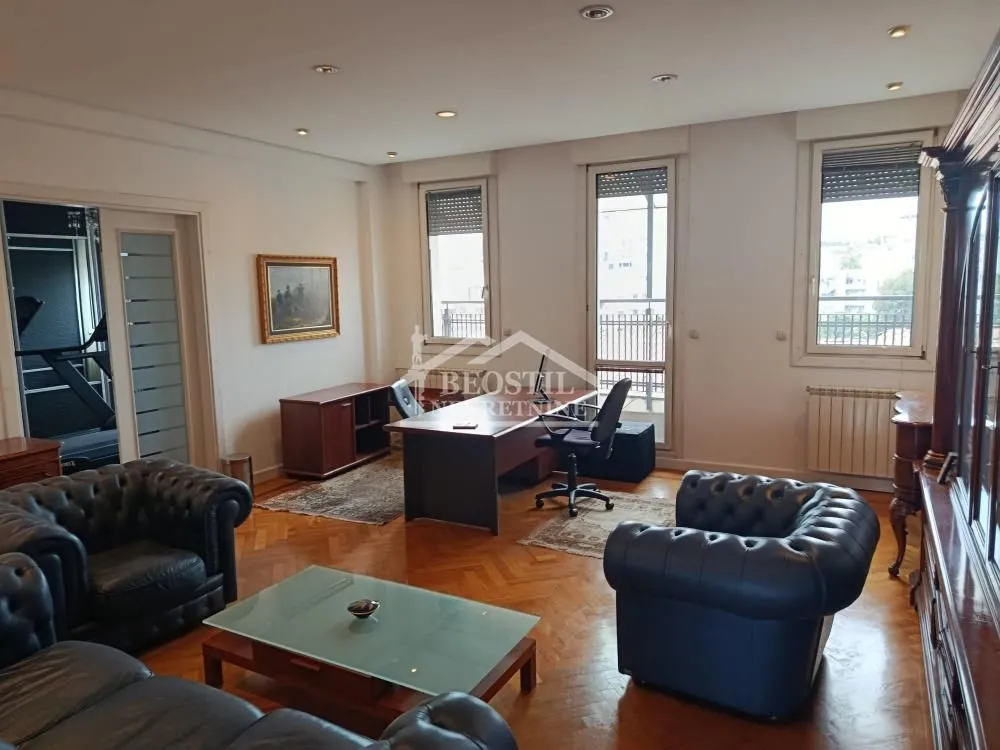 Spacious living room with seating set and a desk.